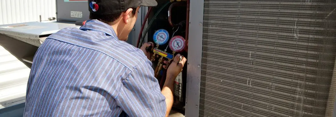 HVAC technician servicing a condenser unit in Berkeley